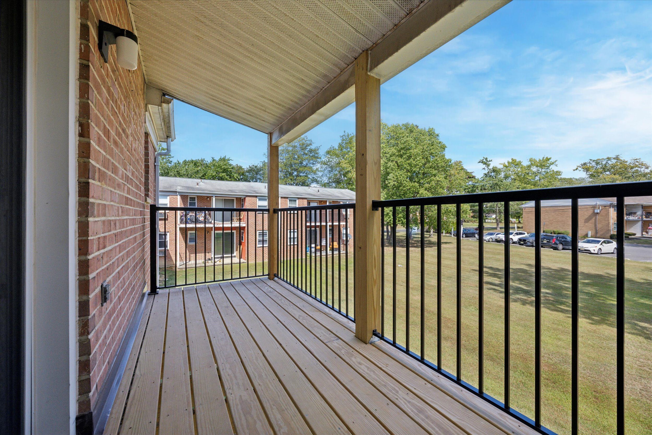 A wooden deck with a black railing and a white door.